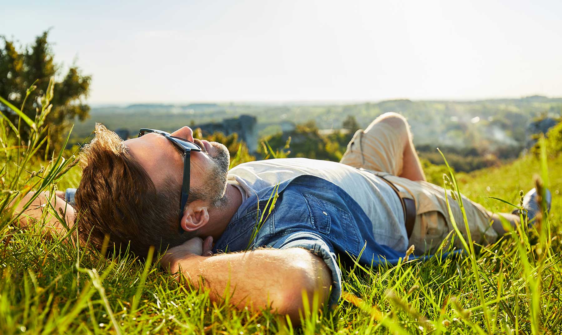 Guy relaxed in the prairie taking a rest.